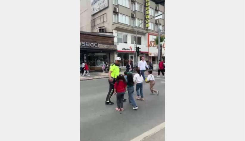 Trafik polisi trafiği kesti, çocukları karşıdan karşıya geçirdi